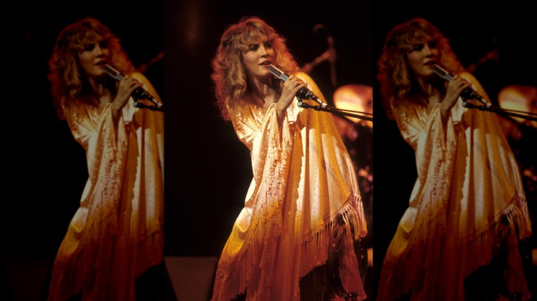Stevie Nicks sur scène drapée dans un châle soyeux