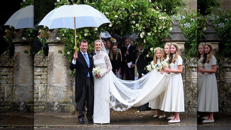 Photo de mariage montrant Peter Phillips tenant un parapluie avec Harriet Sperling, tandis que les trois filles du couple tiennent l'extrémité du train