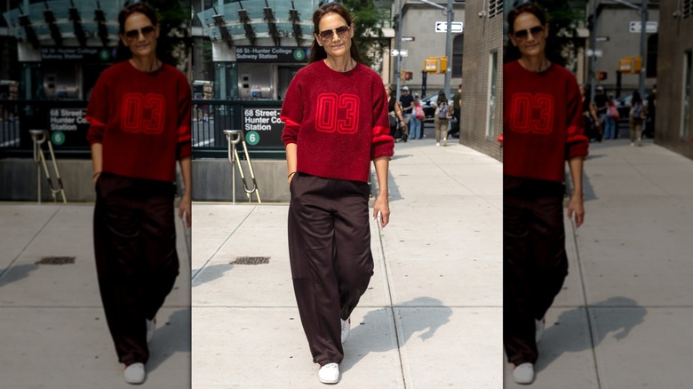 Katie Holmes en pantalon marron et pull rouge
