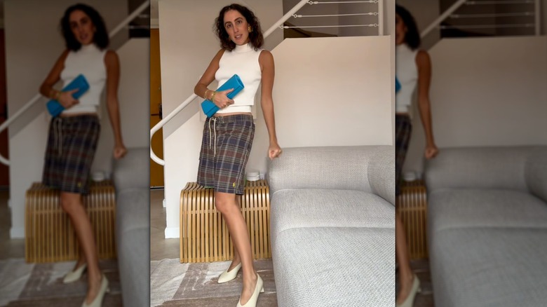 Une femme sur un short de style TikTok avec une pochette bleue et des talons blancs