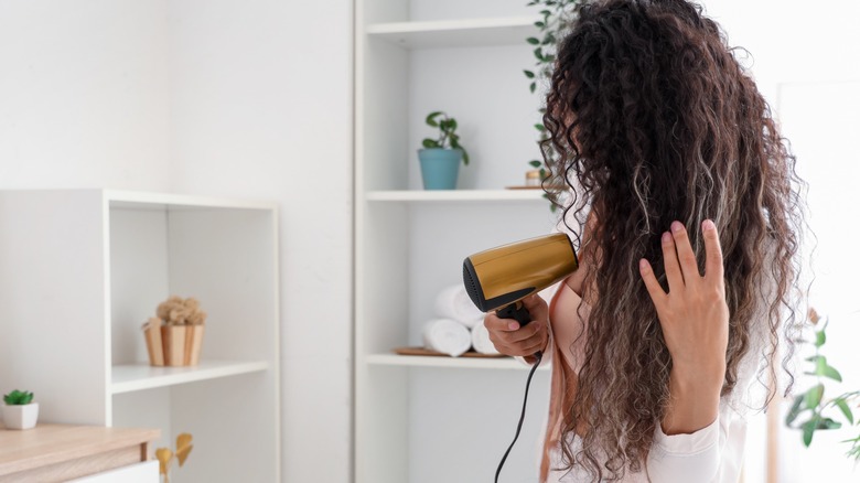 Une femme séchant ses cheveux bouclés