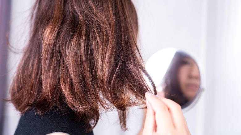 Une femme touchant ses cheveux secs et courts