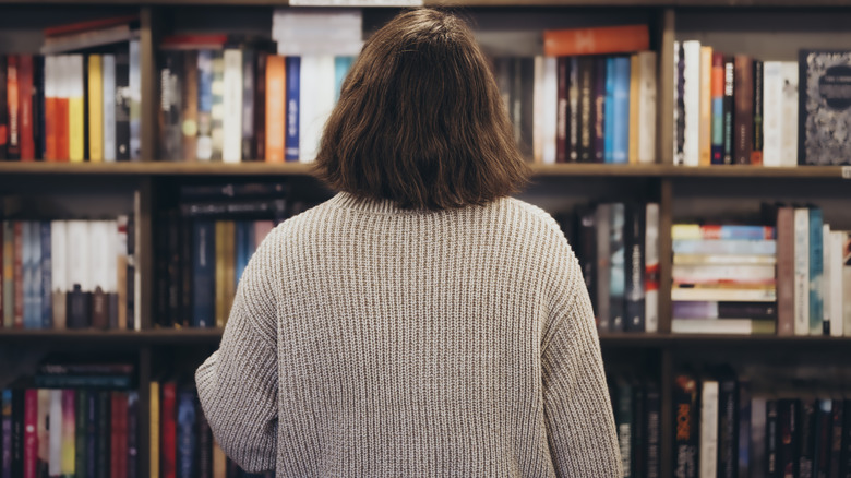 Femme regardant une étagère