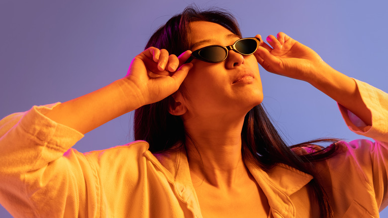 Femme portant des lunettes de soleil micro sur fond violet