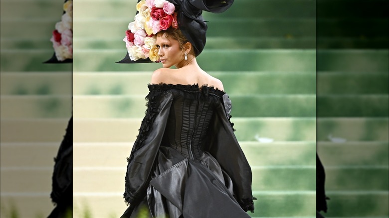 Zendaya au Met Gala portant une robe noire et un casque à fleurs