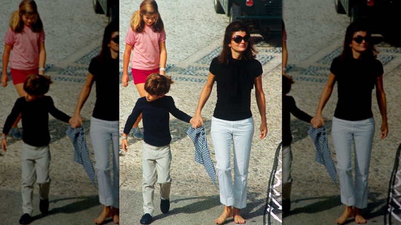 Jackie Kennedy en pantalon blanc et chemise noire avec ses enfants