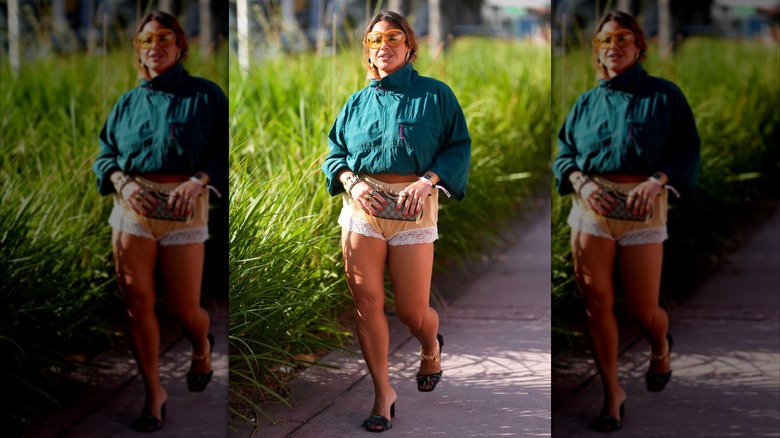 Une femme portant un short bordé de dentelle beige avec une veste verte