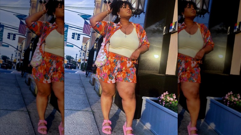 Une femme portant un ensemble coloré, comprenant un short et des sandales roses