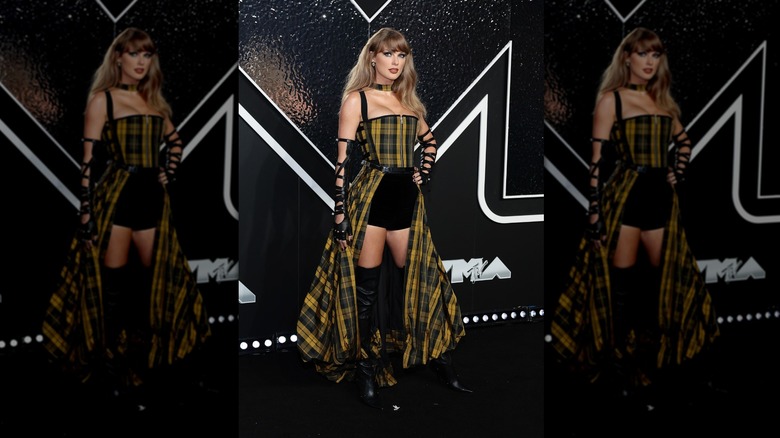Taylor Swift pose avec un corset et une jupe tartan