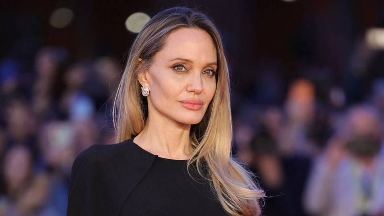 Angelina Jolie dans une robe noire avec de longs cheveux blonds lors d'un événement