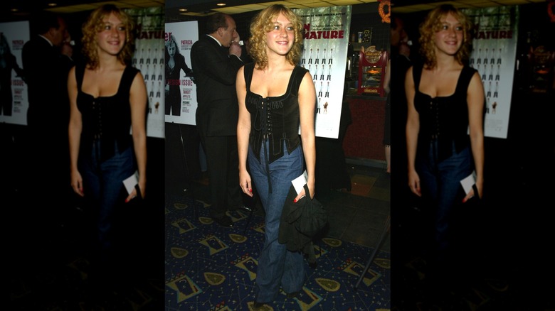 Chloë Sevigny souriant sur le côté tout en portant un haut corset lors de l'avant-première d'un film en 2002