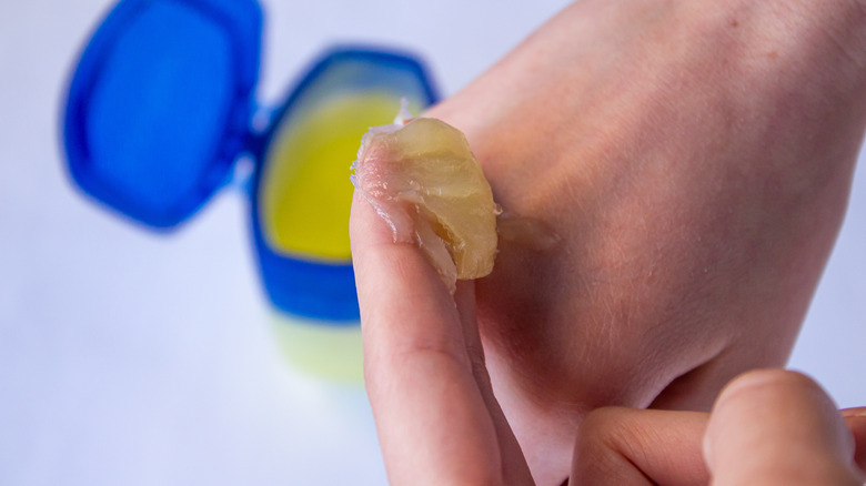 Personne mettant de la vaseline sur sa main