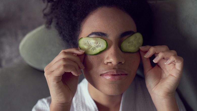 Femme couchée avec des concombres sur les yeux