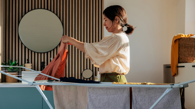 Femme pliant le linge sur un étendoir