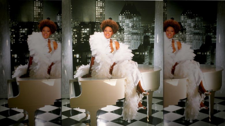 Dionne Warwick est assise sur un piano couvert de plumes blanches