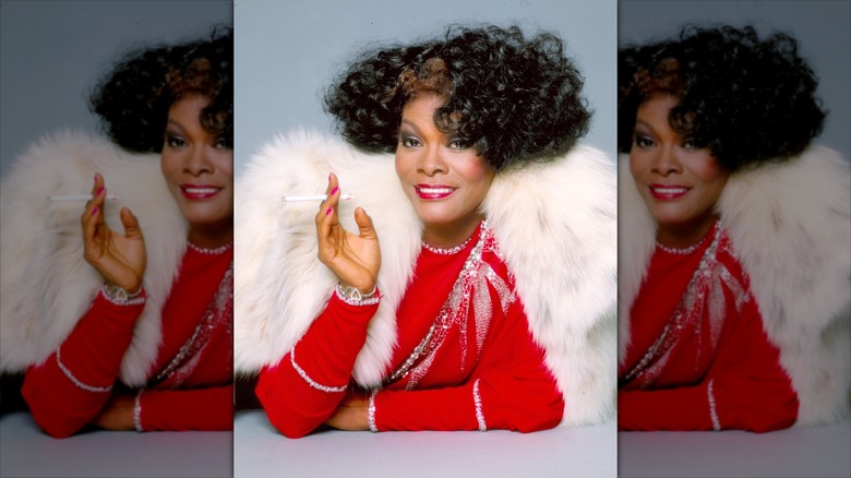 Dionne Warwick sourit en portant un boléro en fourrure et un haut rouge