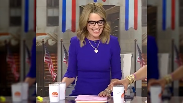 Savannah Guthrie sourit aujourd'hui alors qu'elle était assise derrière un bureau dans une robe bleue