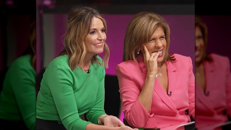 Savannah Guthrie, dans un haut vert, assise à côté de Hoda Kotb dans un blazer rose
