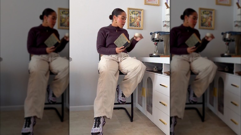 Une femme portant des baskets HOKA avec un pantalon cargo blanc et un pull marron