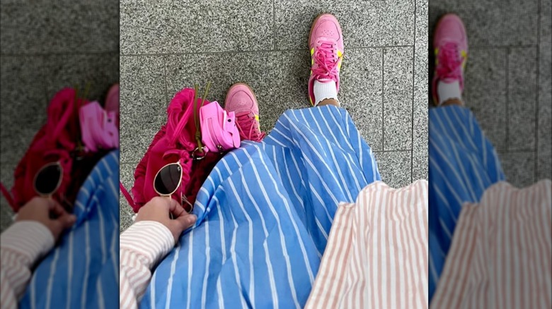 Un gros plan de chaussures Adidas roses avec une jupe bleue et blanche