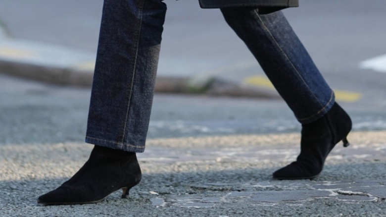 Une femme portant des bottines noires avec un jean cloisonné