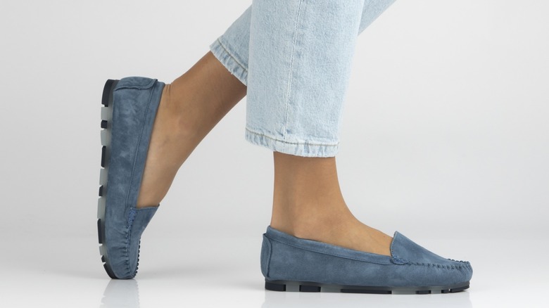 Une personne portant un jean cloisonné clair avec des mocassins