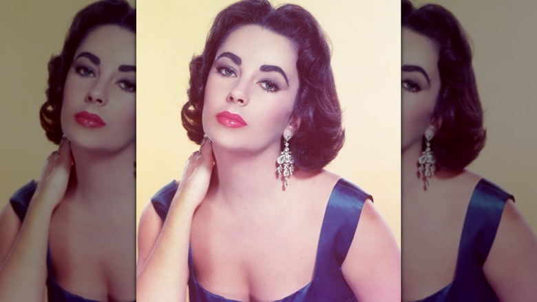 Instantané vintage d'Elizabeth Taylor regardant la caméra avec une main sur le cou