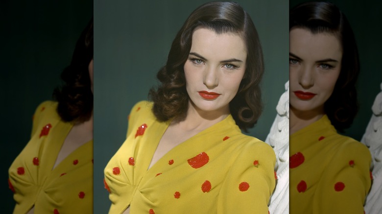 Photographie vintage en couleur d'Ella Raines regardant l'appareil photo tout en portant un chemisier jaune à pois