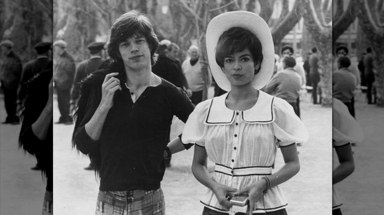Bianca Jagger avec un chapeau et un chemisier à volants et Mick Jagger dans une chemise noire