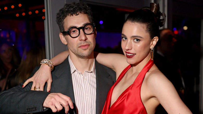 Margaret Qualley en rouge et Jack Antonoff en lunettes noires lors d'un événement