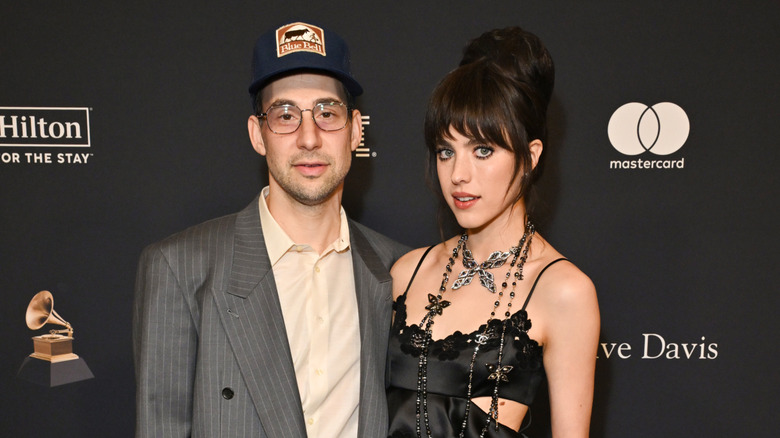 Jack Antonoff portant une casquette et Margaret Qualley portant une robe noire lors d'un événement
