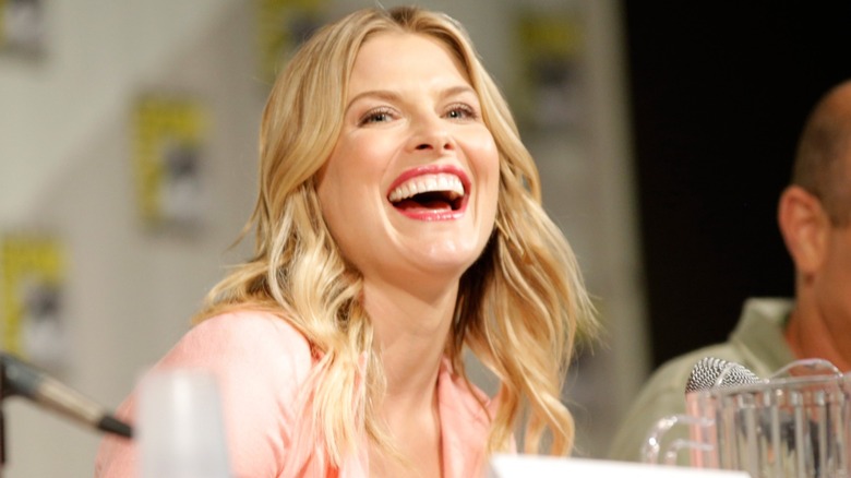 Ali Larter avec des vagues de plage portant un haut rose et un rouge à lèvres corail