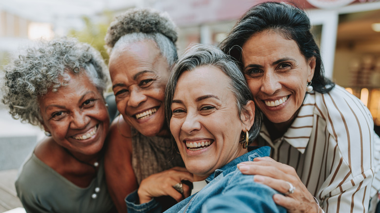 Groupe de femmes plus âgées souriant et prenant un selfie
