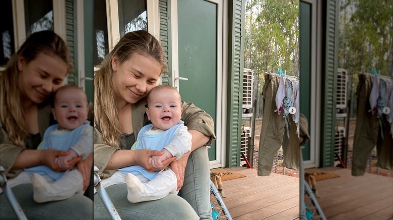Bindi Irwin assise sur un porche et serrant dans ses bras sa fille Grace, un bébé souriant
