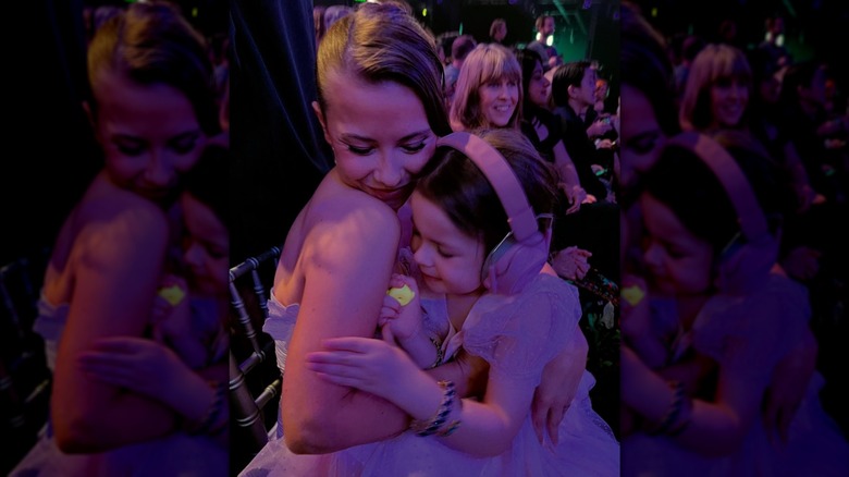 Bindi Irwin serre sa fille Grace dans ses bras dans une pièce sombre éclairée par une lumière violette