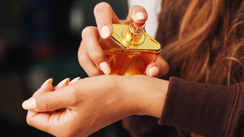 Une femme vaporisant du parfum sur son poignet