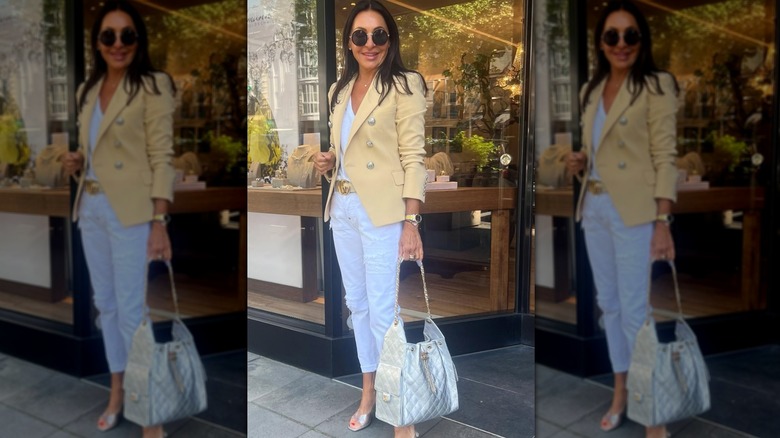 Femme en blazer jaune beurre avec boutons argentés portant un sac et des accessoires argentés