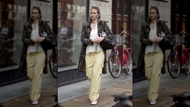 Femme en pantalon jaune beurre et veste à imprimé zèbre