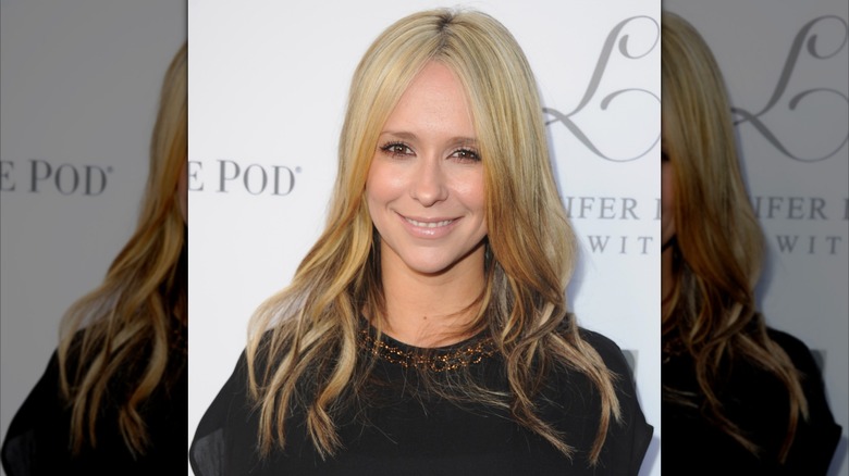 Jennifer Love Hewitt souriante sur le tapis rouge avec des cheveux longs blonds en haut et bruns en dessous