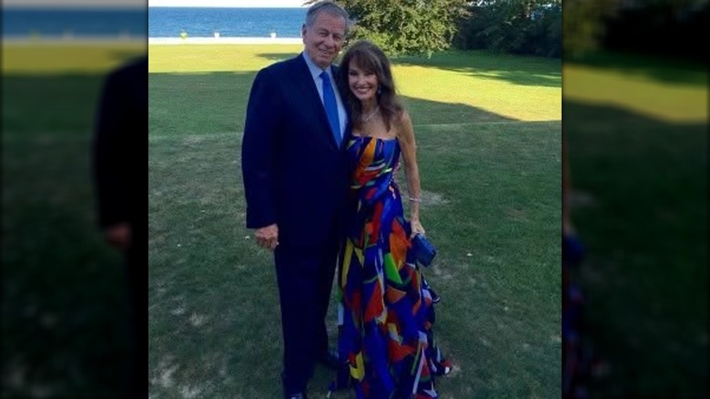 Helmut Huber et Susan Lucci posant ensemble lors du mariage de leur fils devant l'herbe et l'océan