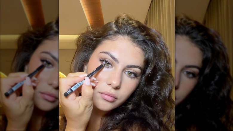 Une femme appliquant un eye-liner au charbon dans une vidéo de maquillage sur Instagram