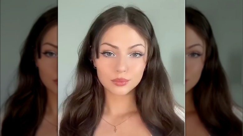 Une femme brune avec un eye-liner blanc dans une vidéo sur Instagram