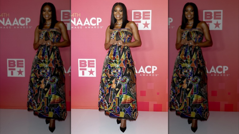 Gabrielle Union posant aux NAACP Image Awards tout en portant une robe colorée jusqu'aux chevilles de Versace