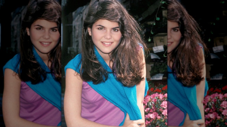 Lori Loughlin portant un cardigan bleu et un haut rose
