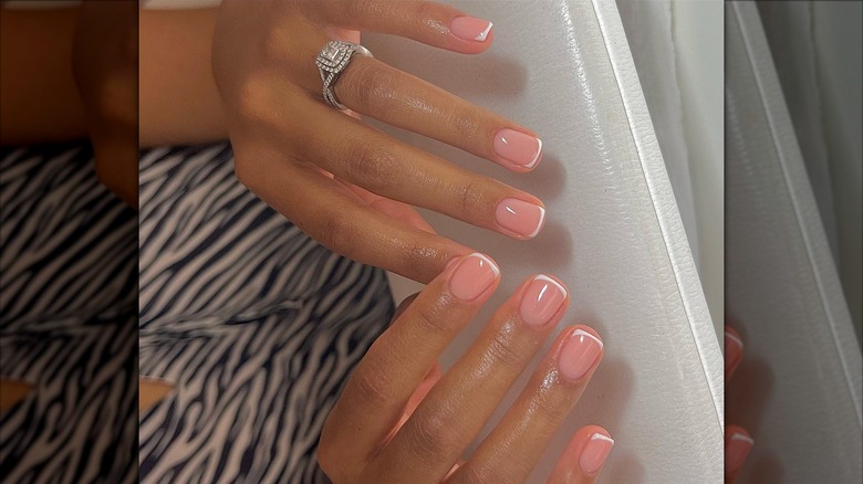 Les mains d'une femme avec une courte manucure française