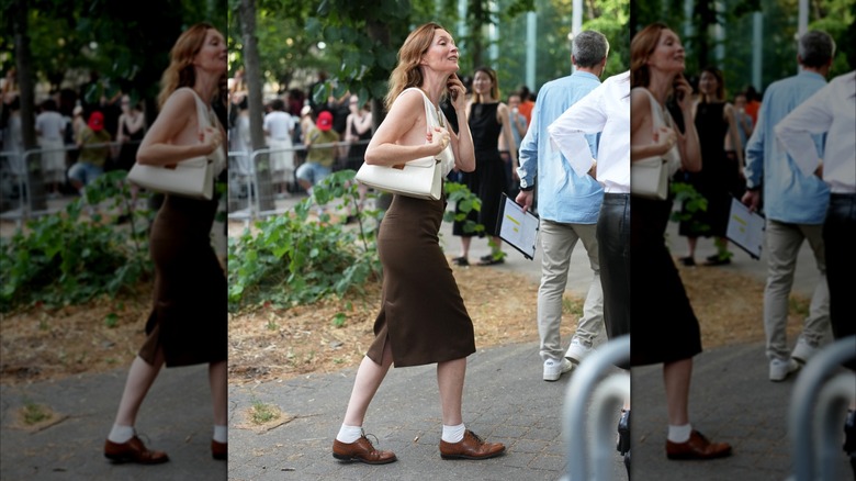 Une femme marchant dans la rue dans une rue marron et des chaussures derby marron