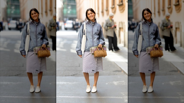 Une femme dans la rue portant une chemise, un coupe-vent et des chaussures derby crème