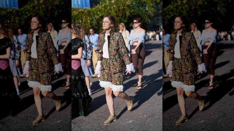 Une femme portant un ensemble à volants fleuris et des chaussures derby crème
