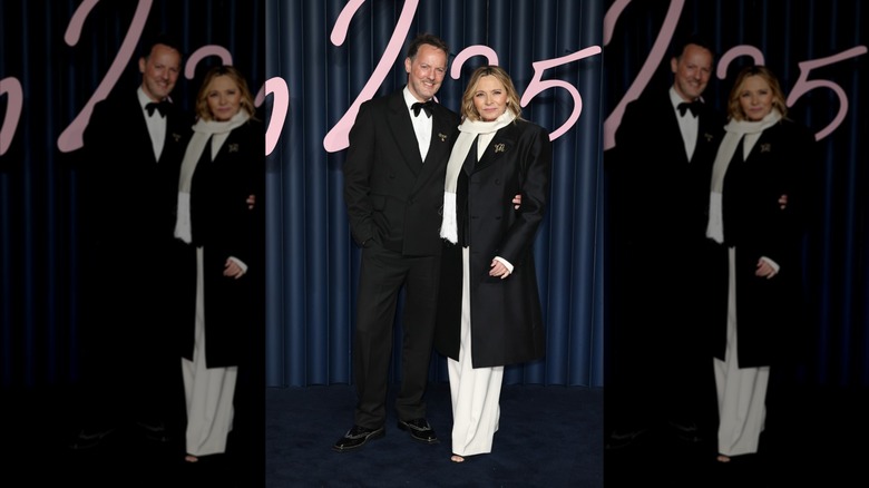 Kim Cattrall vêtue de noir et blanc sur le tapis rouge à côté de son partenaire Russell Thomas