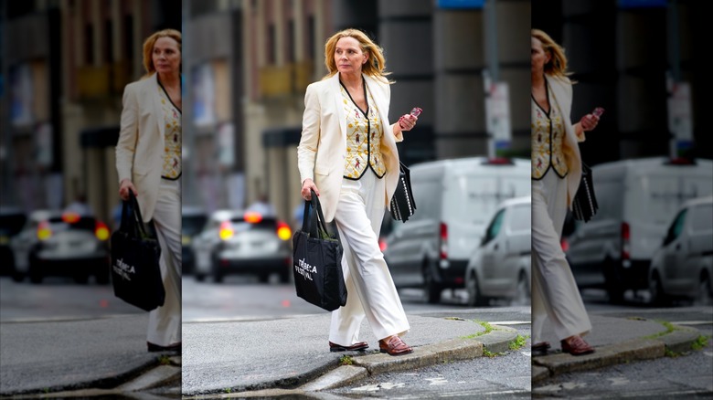 Kim Cattrall porte une tenue entièrement blanche avec un gilet crème